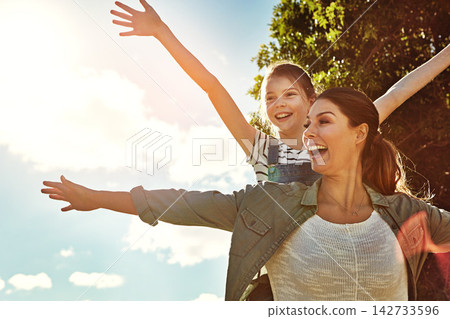 Playing airplane, girl and mom in outdoor park with blue sky for game, fun and bonding together. Nature, happy mother and young daughter for flying arms, summer vacation or weekend in Montana Playing airplane, girl and mom in outdoor park with blue sky for game, fun and bonding together. Nature, happy mother and young daughter for flying arms, summer vacation or weekend in Montana 142733596