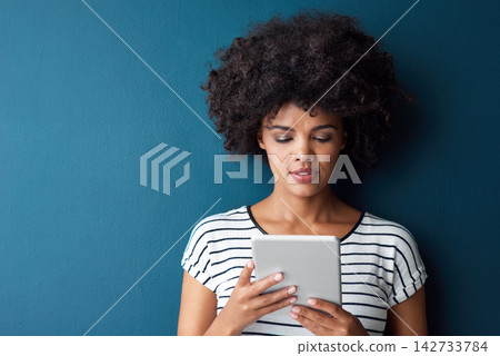 African woman, tablet and space in studio for mockup with reading on app, study or quiz by blue background. Person, girl and student with digital touchscreen, online course or elearning for education 142733784