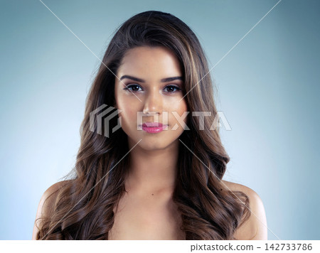 Beauty, makeup and skincare with portrait of woman in studio on blue background for aesthetic wellness. Cosmetics, face and hair with confident model at salon for dermatology or vitamin c treatment Beauty, makeup and skincare with portrait of woman in studio on blue background for aesthetic wellness. Cosmetics, face and hair with confident model at salon for dermatology or vitamin c treatment 142733786