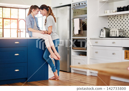 Mother, daughter and love with kitchen, talk and gossip for bonding and parenting. Family, smile and happiness with home, discussion and conversation for care and child chat together for relaxing 142733800