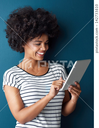 Studio, black woman and digital tablet for typing, conversation and social media with smile. Blue background, girl and technology for networking, scrolling and reading or chat on online application Studio, black woman and digital tablet for typing, conversation and social media with smile. Blue background, girl and technology for networking, scrolling and reading or chat on online application 142733810
