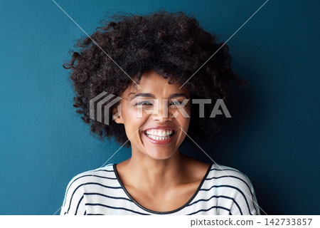 Happy, smile and portrait for African woman, studio and confidence for laugh and joy. Excited, pride and face with isolated person for cheerful, afro and positive fun attitude on blue background 142733857