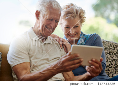 Mature couple, lounge and streaming with tablet, digital and online for search, watch and show on app in house. Conversation, man and woman with news to relax in home, smile and download of movie Mature couple, lounge and streaming with tablet, digital and online for search, watch and show on app in house. Conversation, man and woman with news to relax in home, smile and download of movie 142733886