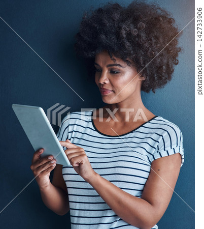 Studio, black woman and digital tablet for reading, conversation and social media with smile. Blue background, girl and technology for networking, scrolling and typing or chat on online application Studio, black woman and digital tablet for reading, conversation and social media with smile. Blue background, girl and technology for networking, scrolling and typing or chat on online application 142733906