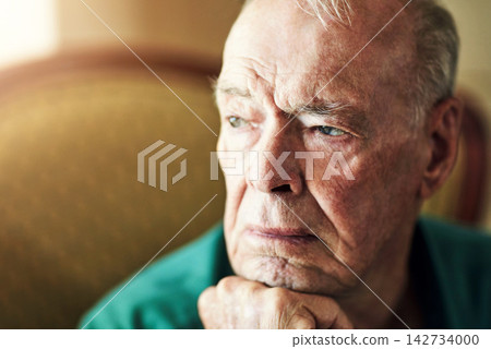 Senior, man and lonely with thinking of memory in retirement home with remember, nostalgia or reflection on sofa. Elderly, person and sad with alzheimers, depression and thoughtful on couch in lounge 142734000