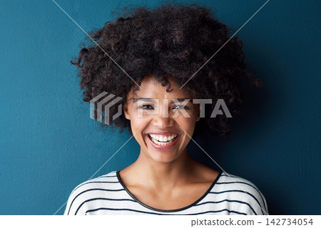 Black woman, portrait and smile with funny, glow and confident on blue studio background. Girl, face and model with afro laughing for comic, joke and happiness or positive with natural beauty 142734054