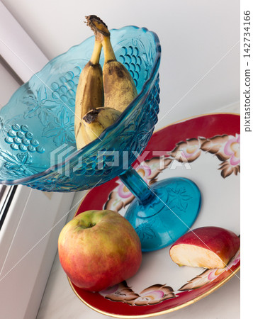 A banana and an apple on a plate. A banana and an apple on a plate. 142734166