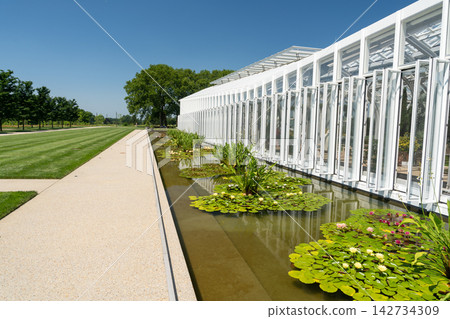 Modern conservatory with a water lily pond and large lawn Modern conservatory with a water lily pond and large lawn 142734309
