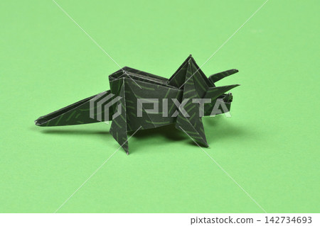 Origami triceratops dinosaur on green background Origami triceratops dinosaur on green background 142734693