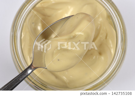 Homemade creamy mayonnaise on a metal spoon 142735108