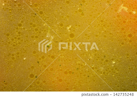 Golden chicken soup texture with oil bubbles Golden chicken soup texture with oil bubbles 142735248