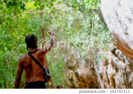 Adventurer man pointing upwards during a jungle exploration hike Adventurer man pointing upwards during a jungle exploration hike 142737111