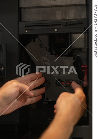Hands removing coffee machine water circuit component for cleaning maintenance in kitchen setting Hands removing coffee machine water circuit component for cleaning maintenance in kitchen setting 142737718