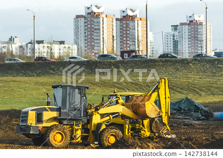 Broken two bulldozers at a construction site on the background of cars and urban buildings Broken two bulldozers at a construction site on the background of cars and urban buildings 142738144