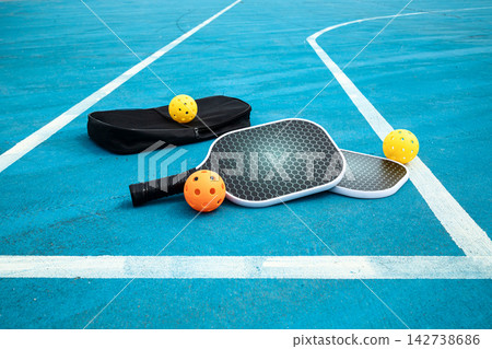 Pickleball paddles and balls on court Pickleball paddles and balls on court 142738686