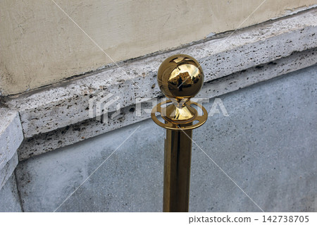Polished Golden Sphere on a Queue Barrier Post Reflecting an Urban Street Polished Golden Sphere on a Queue Barrier Post Reflecting an Urban Street 142738705