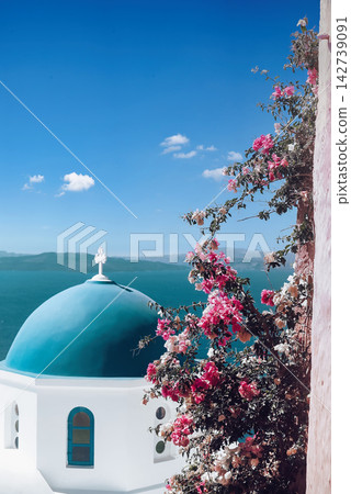 Santorini Greece Blue Dome Church with Bougainvillea Flowers and Sea View 142739091