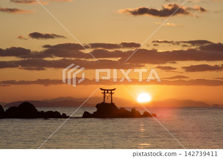 冉冉升起的太陽透過雲層,將納塔海灘染成一片金色。 冉冉升起的太陽透過雲層,將納塔海灘染成一片金色。 142739411
