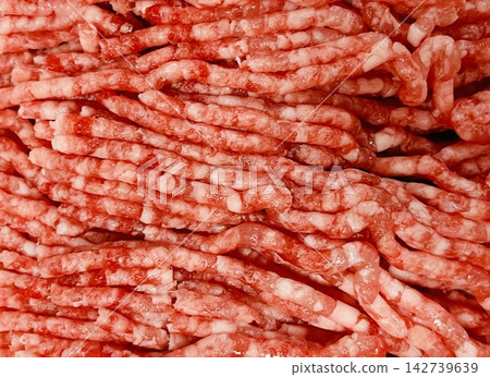 A wide expanse of raw ground meat, showcasing the texture of lean and fatty meat. A wide expanse of raw ground meat, showcasing the texture of lean and fatty meat. 142739639