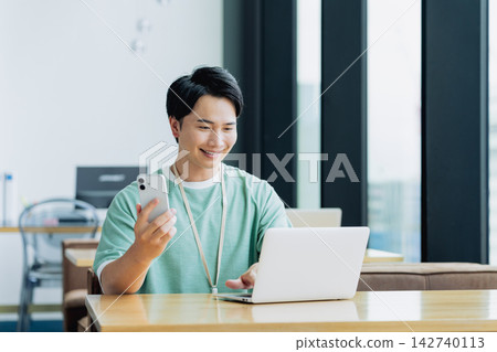 年輕工程師在辦公室使用智能手機 年輕工程師在辦公室使用智能手機 142740113