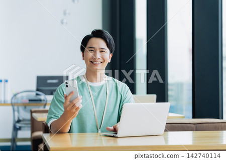 年輕工程師在辦公室使用智能手機 年輕工程師在辦公室使用智能手機 142740114