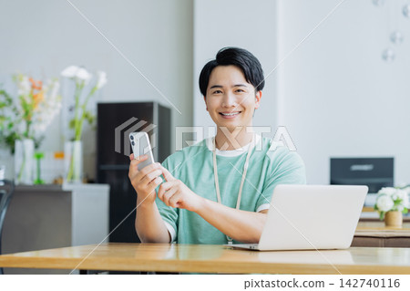 年輕工程師在辦公室使用智能手機 年輕工程師在辦公室使用智能手機 142740116