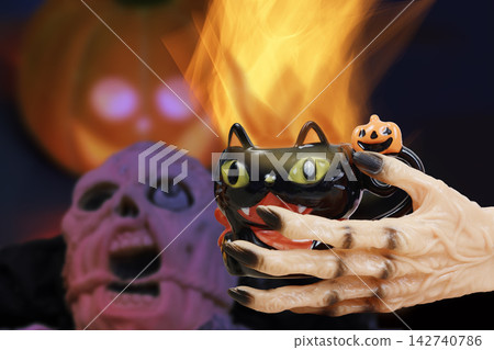 A withered demonic hand holding a drink evokes the atmosphere of a Halloween celebration. A withered demonic hand holding a drink evokes the atmosphere of a Halloween celebration. 142740786