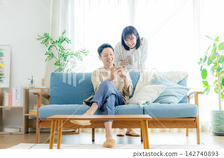 一對夫婦在客廳看智慧型手機 142740893