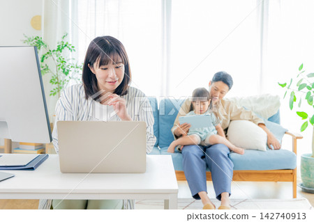 A child studying in the living room and a mom working. A child studying in the living room and a mom working. 142740913