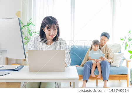 A child studying in the living room and a mom working. A child studying in the living room and a mom working. 142740914