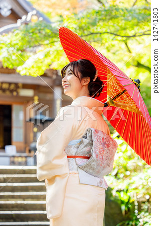 一位身穿和服的女子手持日式雨傘。 142741803
