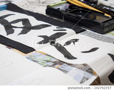 小學生在家練習,準備新年書法比賽。 小學生在家練習,準備新年書法比賽。 142742357