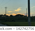 A rural landscape at dusk and an orange sky 142742756
