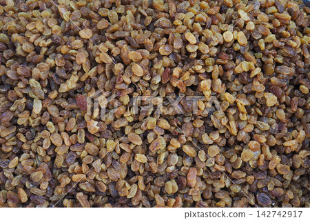 Dried raisins are displayed on a market table in bright sunlight Dried raisins are displayed on a market table in bright sunlight 142742917