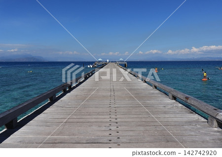 A pier stretching out into the blue sea A pier stretching out into the blue sea 142742920