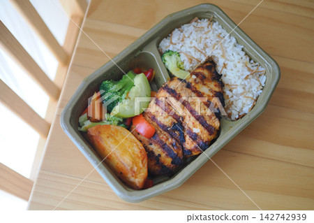 Grilled chicken with rice and vegetables in a takeaway container Grilled chicken with rice and vegetables in a takeaway container 142742939