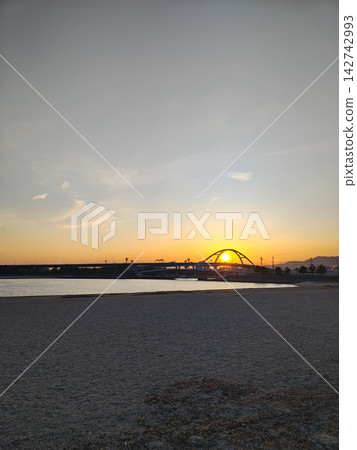 美麗的夕陽緩緩沉入拱橋的輪廓之後,為廣闊的沙灘(甲子園濱海濱公園)營造出令人驚嘆的傍晚景色。 美麗的夕陽緩緩沉入拱橋的輪廓之後,為廣闊的沙灘(甲子園濱海濱公園)營造出令人驚嘆的傍晚景色。 142742993
