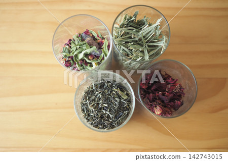 Dried herbs and flowers in glass jars on a wooden table Dried herbs and flowers in glass jars on a wooden table 142743015