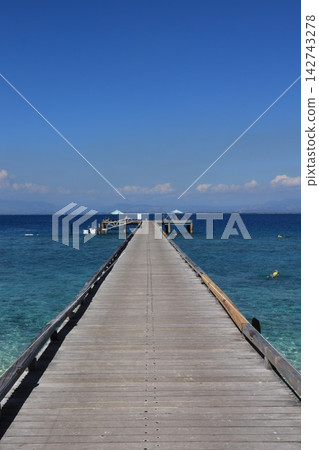 一座碼頭延伸到蔚藍的大海中 一座碼頭延伸到蔚藍的大海中 142743278