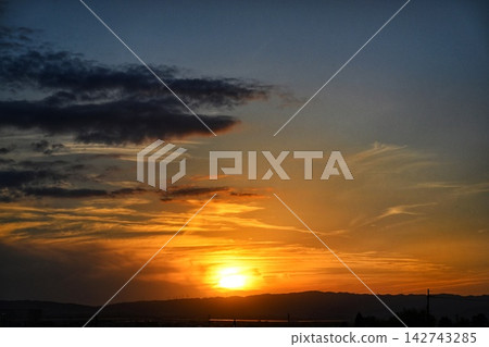 The setting sun shining in crimson and the approaching night sky The setting sun shining in crimson and the approaching night sky 142743285