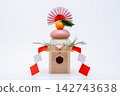 A photograph with a real red and white rice cake ("kagami mochi") placed in the center, against a white background, and with a sanbo (stand). 142743638