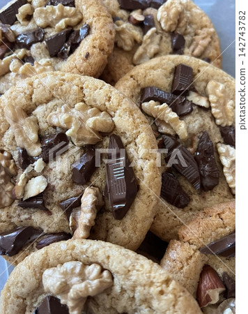 Freshly baked cookies with a golden-brown finish and chocolate chips. Perfectly crisp on the edges with a soft center, offering a delicious, comforting treat for any occasion. Freshly baked cookies with a golden-brown finish and chocolate chips. Perfectly crisp on the edges with a soft center, offering a delicious, comforting treat for any occasion. 142743782