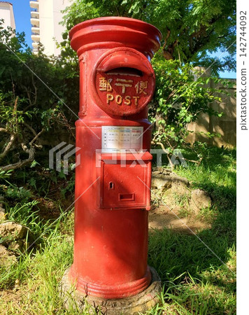 A retro red mailbox, rooted in a place with an exotic atmosphere. A retro red mailbox, rooted in a place with an exotic atmosphere. 142744092