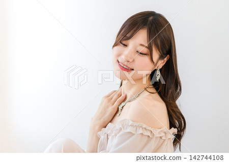 一位擁有令人驚豔的透亮肌膚和光澤秀髮的年輕女子。她是化妝品和護膚品的理想代言人。 一位擁有令人驚豔的透亮肌膚和光澤秀髮的年輕女子。她是化妝品和護膚品的理想代言人。 142744108
