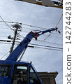 A rough terrain crane and power lines working in a residential area. 142744283