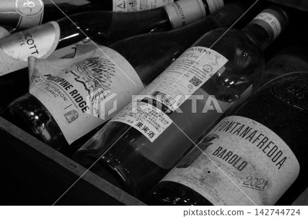 A chic monochrome background image of vintage wines lined up in a wine cellar. A chic monochrome background image of vintage wines lined up in a wine cellar. 142744724