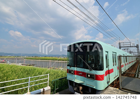 Nishitetsu Railway crosses a railway bridge under a blue sky. Nishitetsu Railway crosses a railway bridge under a blue sky. 142745748