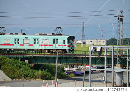 Nishitetsu Railway crosses a railway bridge under a blue sky. Nishitetsu Railway crosses a railway bridge under a blue sky. 142745754