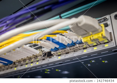 Close-up of multiple colored fiber optic LC connectors and network cables connected to 10G SFP plus switch ports in a professional data center server rack Close-up of multiple colored fiber optic LC connectors and network cables connected to 10G SFP plus switch ports in a professional data center server rack 142746434