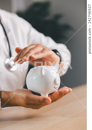 Healthcare professional holding and protecting a white piggy bank, representing medical savings, health insurance, financial security, emergency funds, budgeting, and planning for healthcare costs. Healthcare professional holding and protecting a white piggy bank, representing medical savings, health insurance, financial security, emergency funds, budgeting, and planning for healthcare costs. 142746937